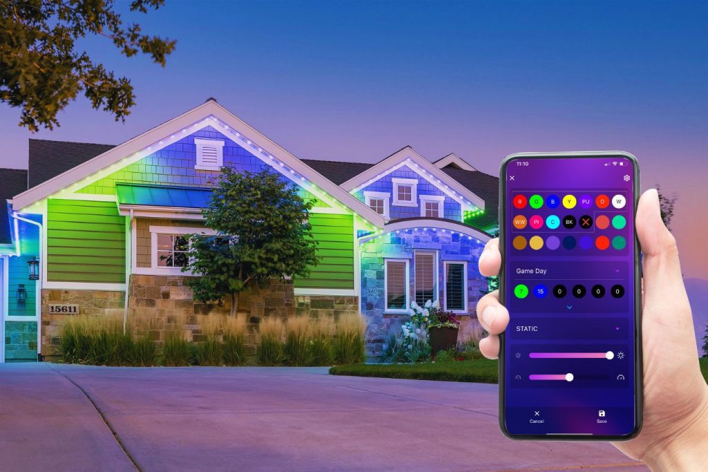 A smartphone displays the Trimlight app while a home glows with programmable colors in the background